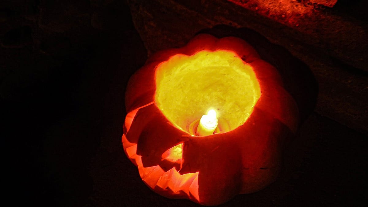 A carved jack-o'-lantern glowing on a dark autumn night