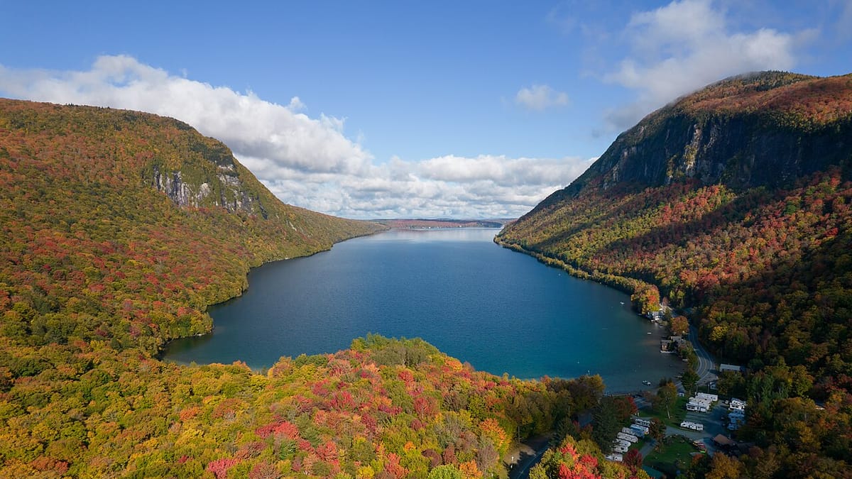 An aerial view of mountains with autumn color sweeping across the slopes